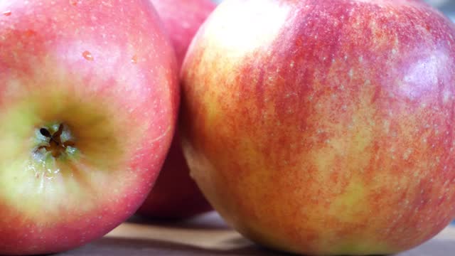 A few wet red apples, 4k macro video. The apples are spinning. Ripe apples.