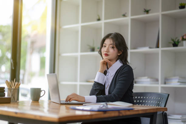istock Asian woman sitting and working on laptop. Thinking plan 2142561585