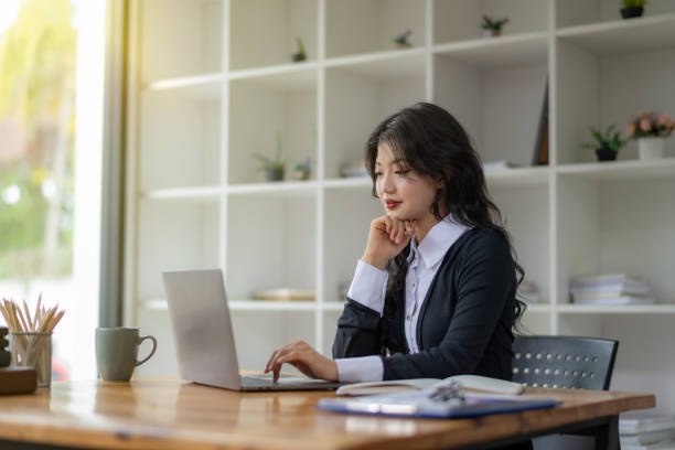 istock Asian woman sitting and working on laptop 2142565251