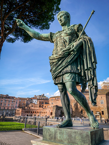 A detailed view of the bronze statue of the Emperor Gaius Iulius Caesar Augustus, also know as Octavian or Augustus, along the Viale dei Fori Imperiali (Avenue of the Imperial Forums), in the ancient heart of Rome. This bronze statue, placed in front of the Forum of Augustus, is a copy of the marble original currently preserved in the Vatican Museums. Caesar Augustus was the first Roman emperor, revered as father of the homeland (Patri Patriae) and artecife of a long period of domination, prosperity and peace throughout the empire, known as Pax Romana or Pax Augustea. The Roman Forum, one of the largest archaeological areas in the world, represented the political, legal, religious and economic center of the city of Rome, as well as the nerve center of the entire Roman civilization. In 1980 the historic center of Rome was declared a World Heritage Site by Unesco. Image in original 4:3 ratio and high definition quality.