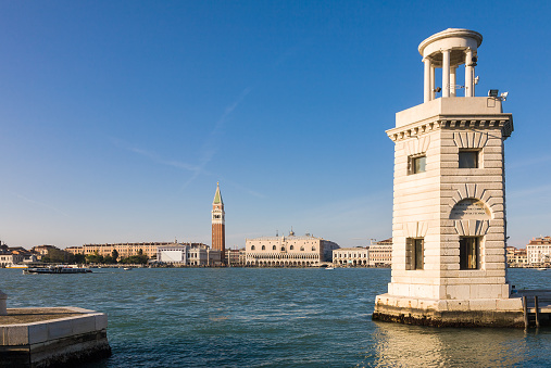 A view on the doge's palace and the bell tower as seen from the port of the island of San Giorgio Maggiore with its lighthouse, Venice, Italy