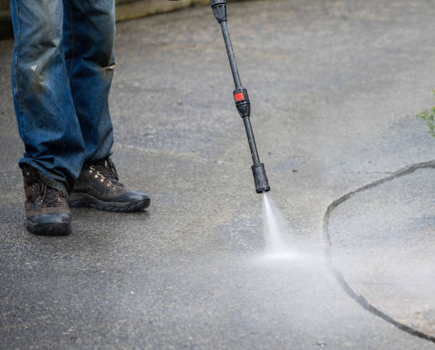 istock Worker cleaning pavement using an electric water blaster. 2142618271