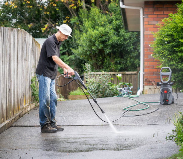 istock Man cleaning concrete driveway using a pressure washer. 2142618794
