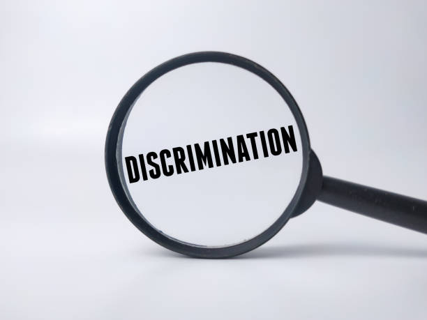 Magnifying glass with the word DISCRIMINATION on a white background.Business concept.