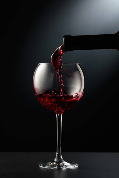 istock Pouring red wine into a wine glass. 2142715272