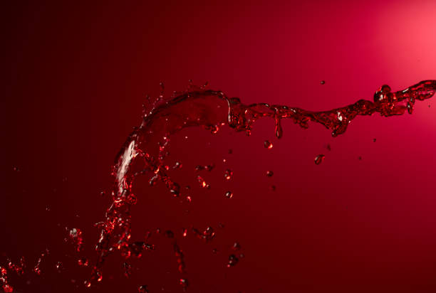 istock Red wine splash on a dark red background. 2142715307