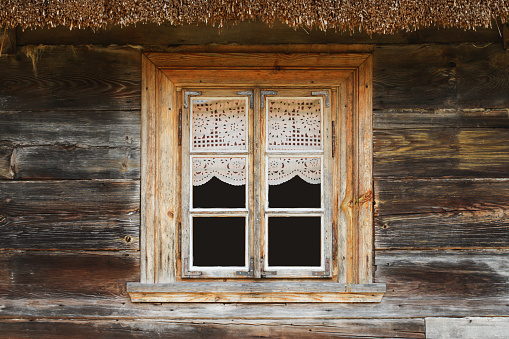 Old wooden window with shutters of an old small wooden cottage in Malopolskie Province, Poland.