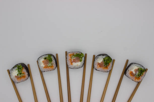 Hand holding chopsticks, isolated on white background.