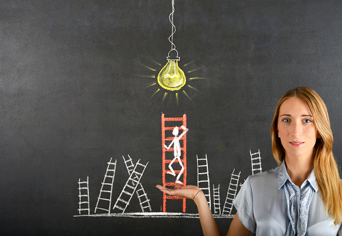 Young woman showing stick figure climbing ladder to success