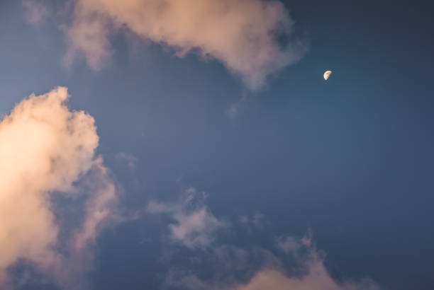 istock The moon glows in the evening blue cloudy sky, minimalistic evening sky for background 2142779659