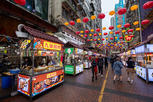 Hong Kong - March 14, 2024 : People visit food stalls at Temple Street Market in Hong Kong.