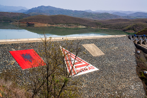 Image of a hydroelectric dam in Qafe Molle, Mirdite, Albania with a large Albanian flag painted on the damn.
