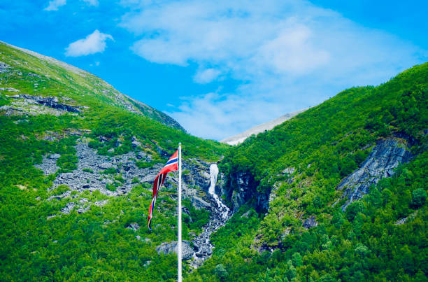 The Norwegian flag with a waterfall backdrop in Valldal.
