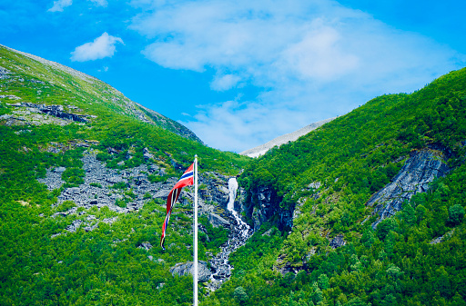 The Norwegian flag with a waterfall backdrop in Valldal.