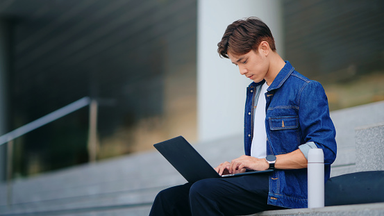 Young Man Working Outdoors on Laptop Remote work lifestyle
