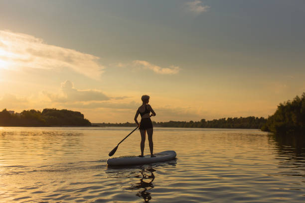 istock Blonde woman on sap board on the river. 2143034854