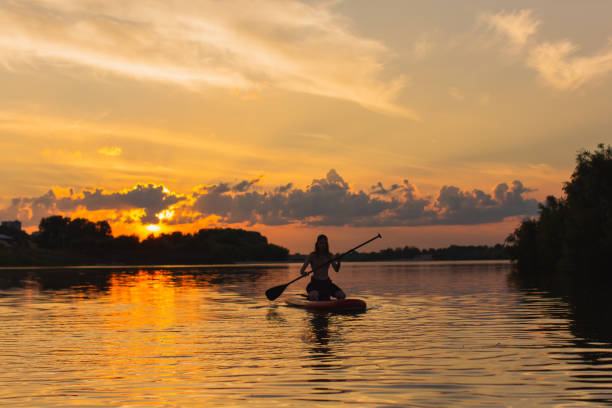 istock Long hair man on sap board on the river. 2143044605