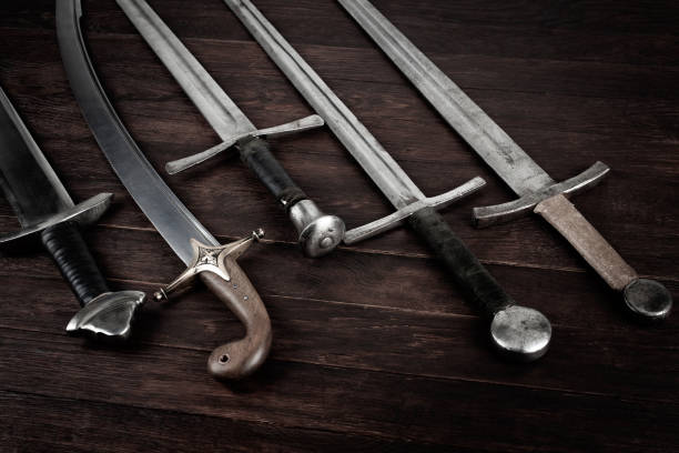 istock Swords and sabre on wooden background. 2143060723
