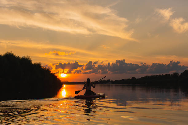 istock Long hair man on sap board on the river. 2143102785