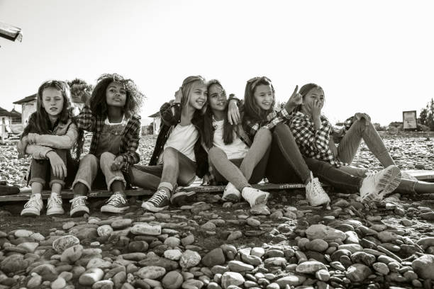 Six girlfriends spend the weekend sitting on a rocky beach
