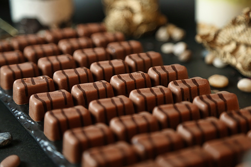 A detailed view of a diverse assortment of chocolates neatly presented on a tabletop.