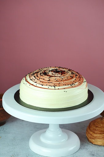 A cake sits atop a white cake plate, creating a visually appealing display.
