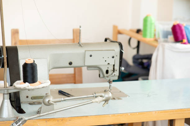 istock Industrial sewing machine with colorful thread, working place, manufacture for clothes, handmade, small local business 2143158424