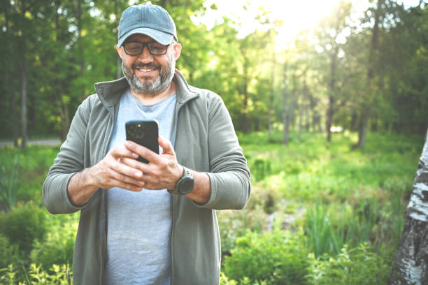 istock Man walking in the park with a mobile phone 2143180700