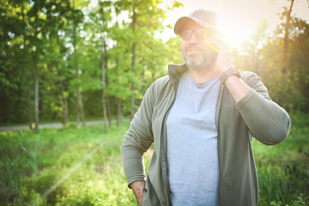 Man walking in the park with a mobile phone