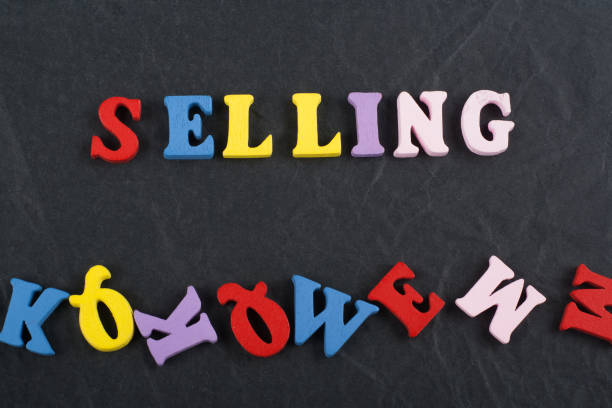 istock SELLING word on black board background composed from colorful abc alphabet block wooden letters, copy space for ad text. Learning english concept. 2143266032