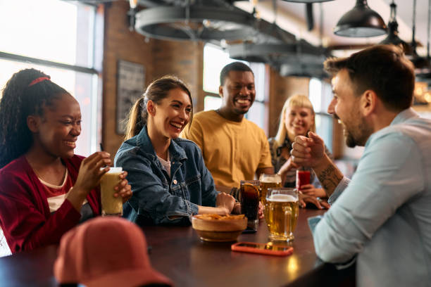 istock Multiracial group of happy friends communicating while gathering in a pub. 2143279220