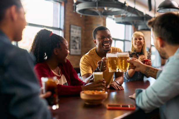 istock Cheerful black man toasting with his friends while drinking beer in a pub. 2143279221