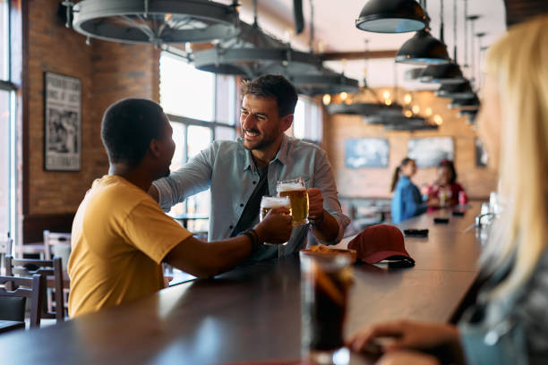 istock Happy male friends toasting with beer in a pub. 2143279762