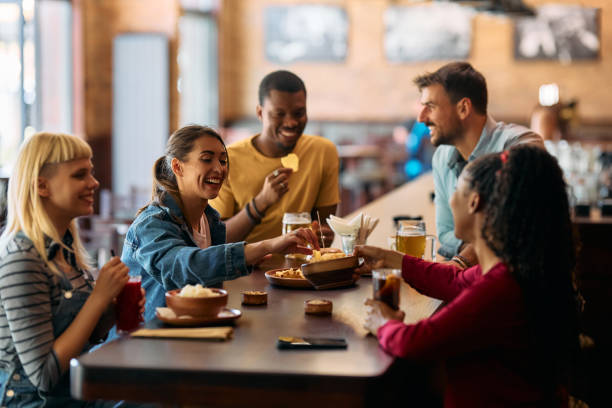 istock Group of happy friends having a snack while drinking in a bar. 2143280308