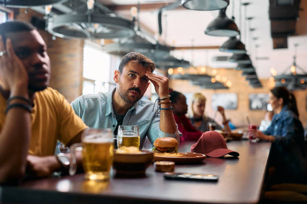 istock Young man watching a match with anticipation in a pub. 2143280320