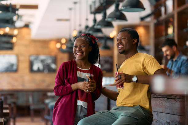 istock Cheerful black couple enjoying while having a drink in a cafe. 2143281910
