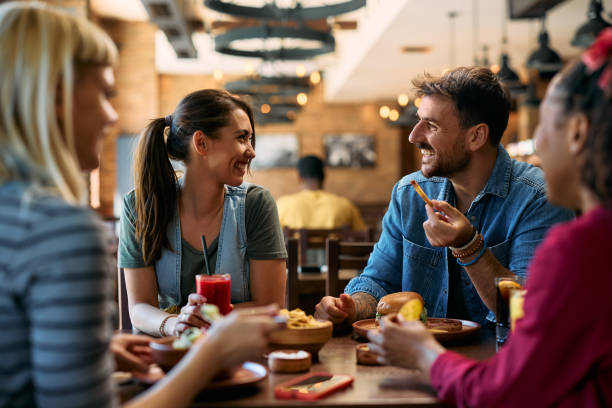 istock Young happy couple communicating while eating in a pub. 2143282423