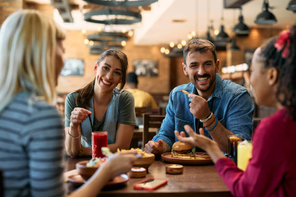 istock Happy couple talking to their friends while having lunch in a tavern. 2143282427