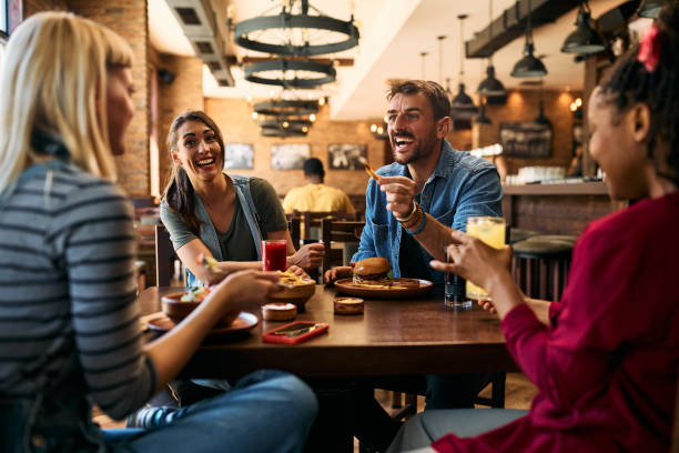 istock Cheerful friends having fun while talking and eating in a pub. 2143282432