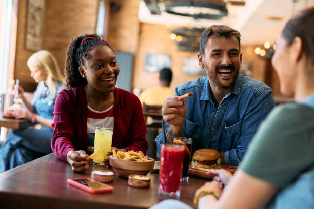istock Young happy man and his friends talking while eating in a pub. 2143282938