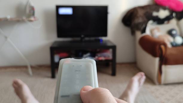 Man switches channels on TV with remote control. A first person view video