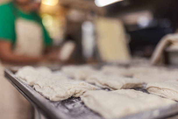 Close-up of croissants in a pan before baking, in the bakery's kitchen