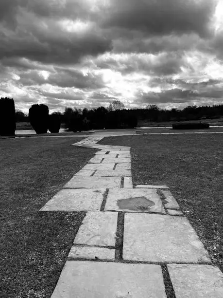 Photo of A zig zagging paved path with stormy clouds overhead