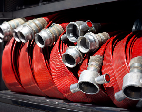 Group of coiled fire hoses typically seen on a fire truck appliance. Fire engine hoses are an essential firefighting apparatus in extinguishing blazes, saving lives and ensuring property safety.