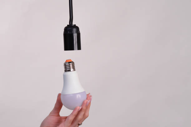 istock woman changing old light bulb for a led energy saving lightbulb 2143338290