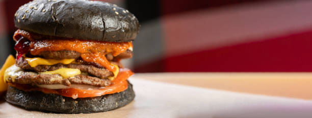 istock Double burger barbeque with beef and tomatoes sauce on black blurred background with free text space. 2143338837