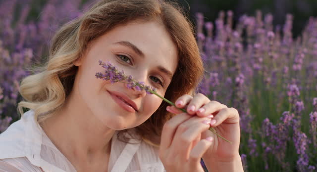 Joyful Moment: Young Woman with Lavender Flowers at Dusk