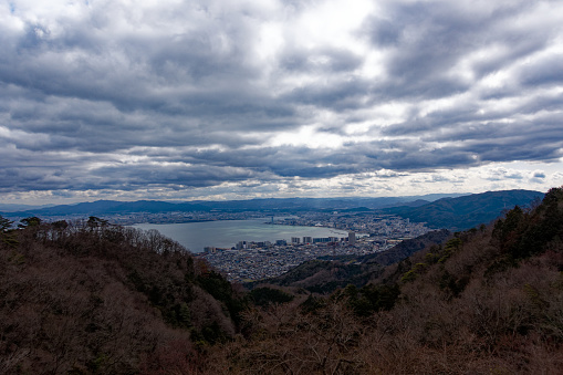 Scenic view from Yumemigaoka View Deck over largest Japanese Lake Biwa with City of Otsu on a cloudy winter day. Photo taken February 8th, 2024, Yumemigaoka, Kyoto, Japan.