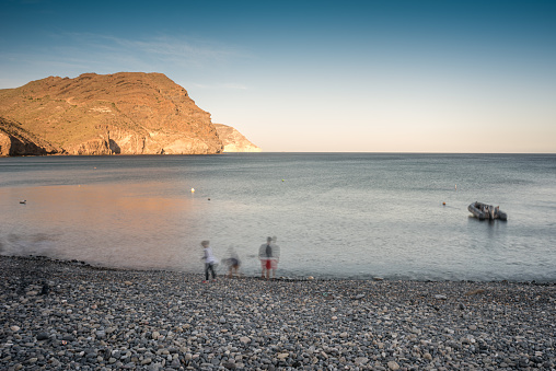 A family enjoys a winter day at a beach cove in Almeria, Andalucia, Spain.