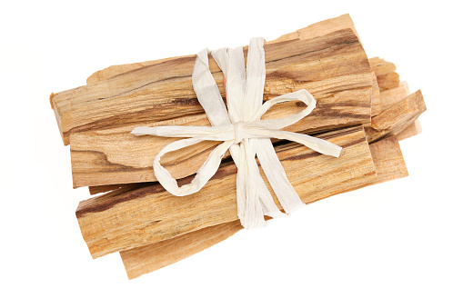 Palo Santo sticks, also called holy wood (Bursera graveolens), a tree species native to South America, used for incense, aromatic oil, and indigenous medicine. Close-up, table top view, isolated on white background.